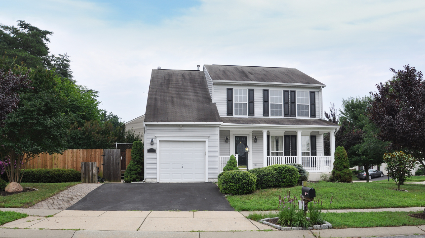 A white house with a blacktop driveway
