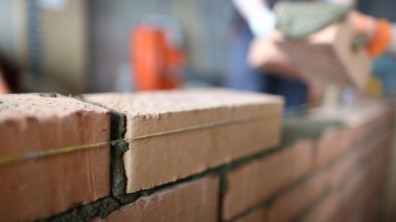 A close up of a brick wall being built.