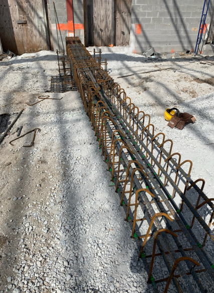 Reinforced steel structure on a gravel surface at a construction site. The rebar is ready for concrete.