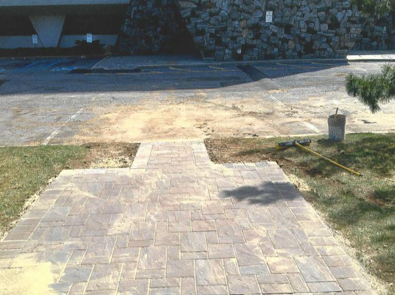 Brick pathway leading to parking lot and building.