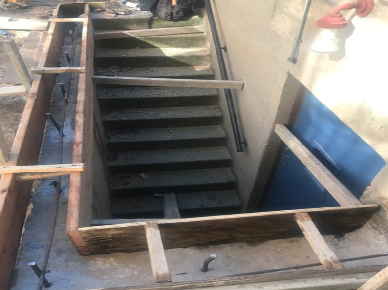 Concrete stairs leading down, with wooden framing for a new structure.