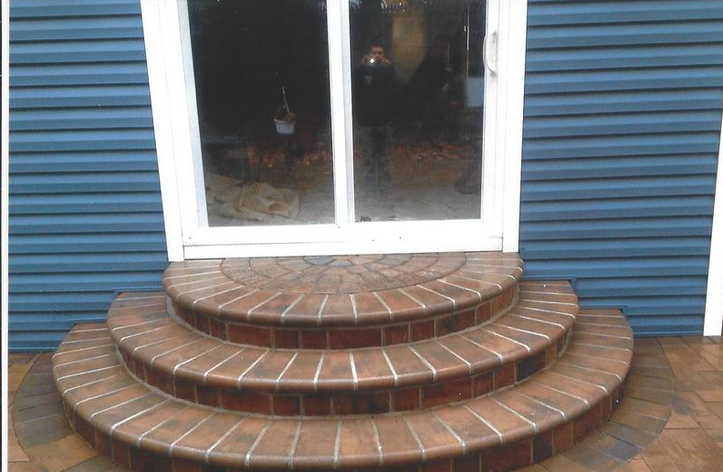 Brick steps leading to a door with blue siding.