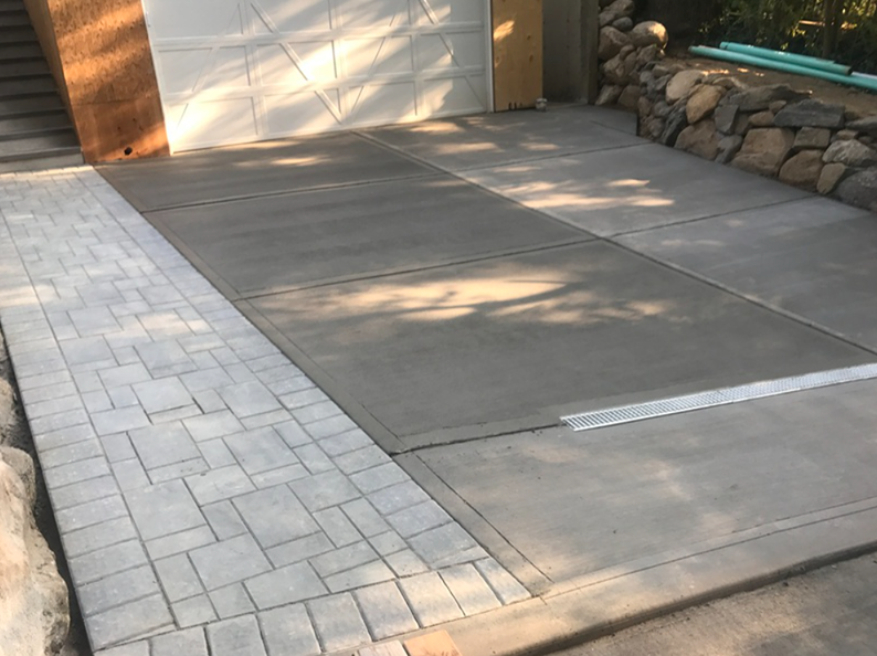 Concrete driveway with paved walkway alongside a garage.
