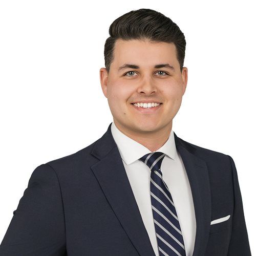 A man in a suit and tie is smiling for the camera.