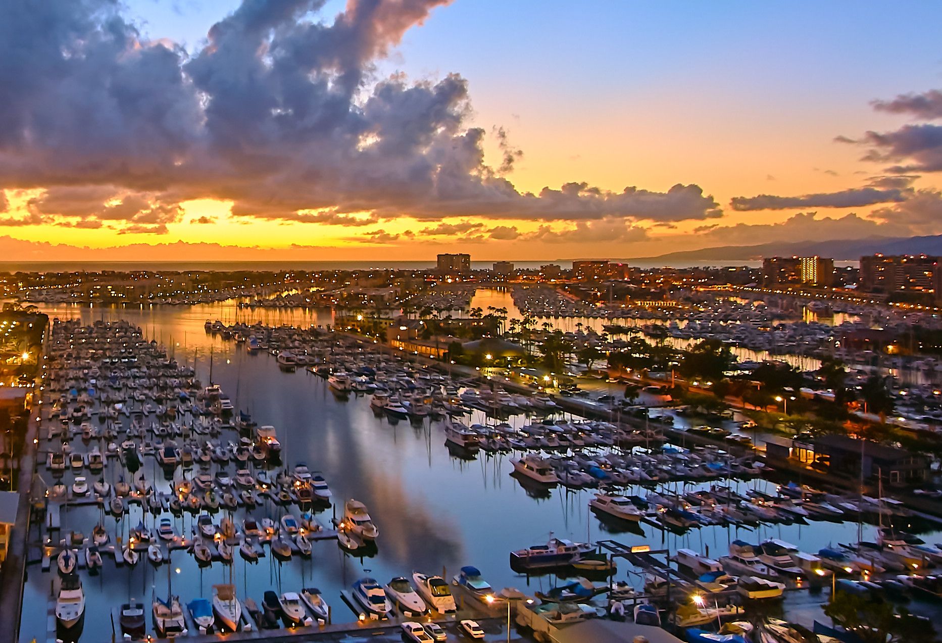 An aerial view of a marina filled with boats at sunset