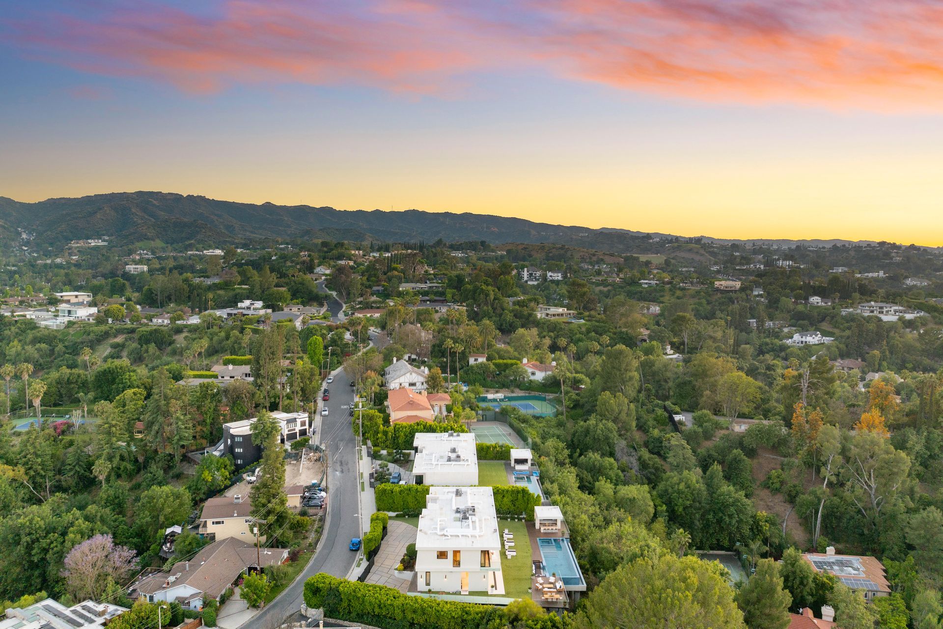 A pier at sunset with a lifeguard tower in the foreground