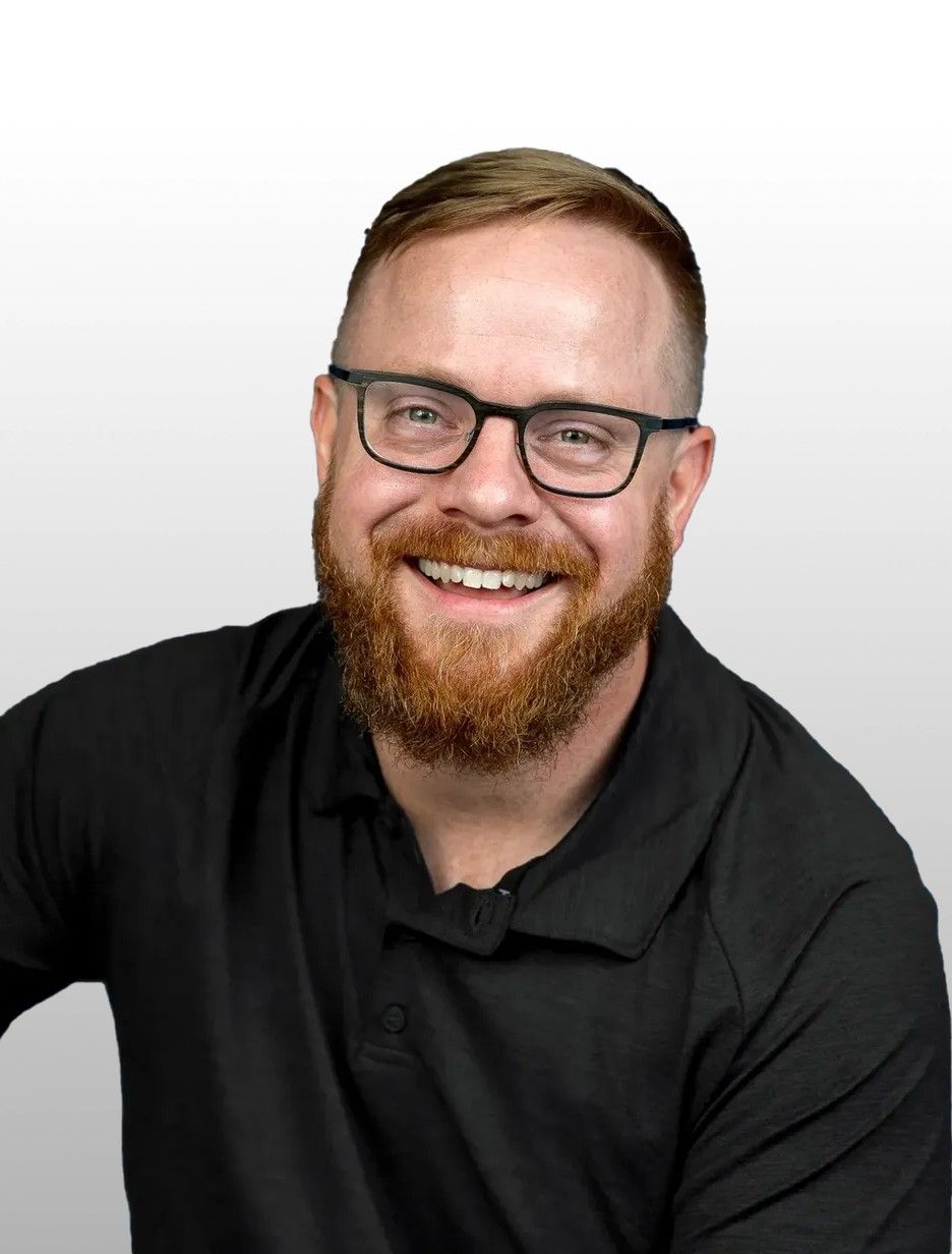 A man in a white shirt is standing in a room.