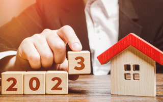 A person is holding a wooden block with the number 3 on it.