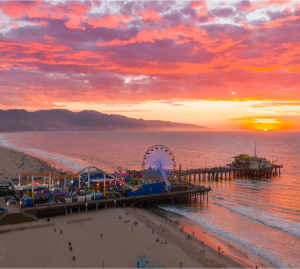 An aerial view of a pier with a ferris wheel at sunset.