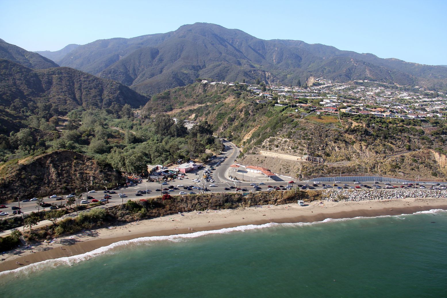 An aerial view of a beach with mountains in the background