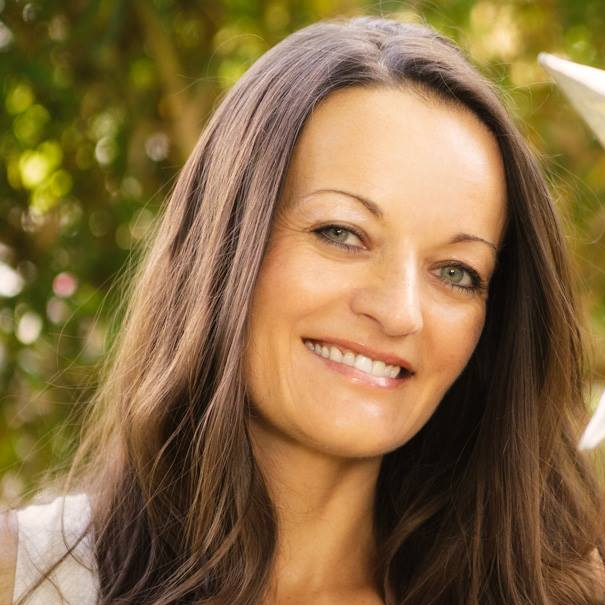 A woman with long brown hair is smiling for the camera
