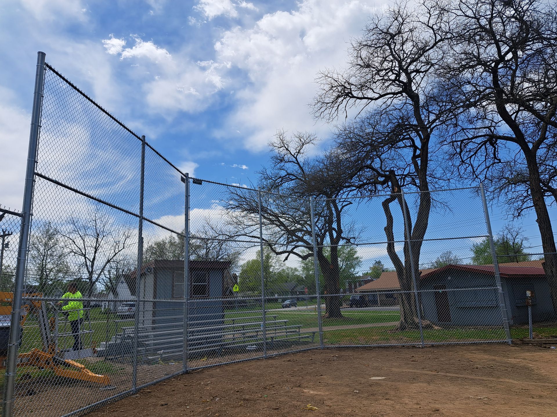 Black chain-link fence against a clear, bright blue sky.