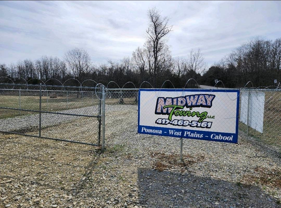 Stack of lumber on a gray industrial container, against a modern building with glass windows.