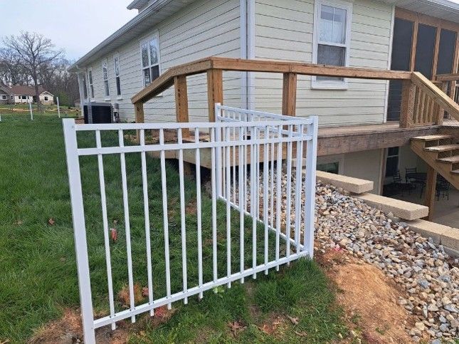 White fencing installation outside of a house. White fencing installation outside of a house.