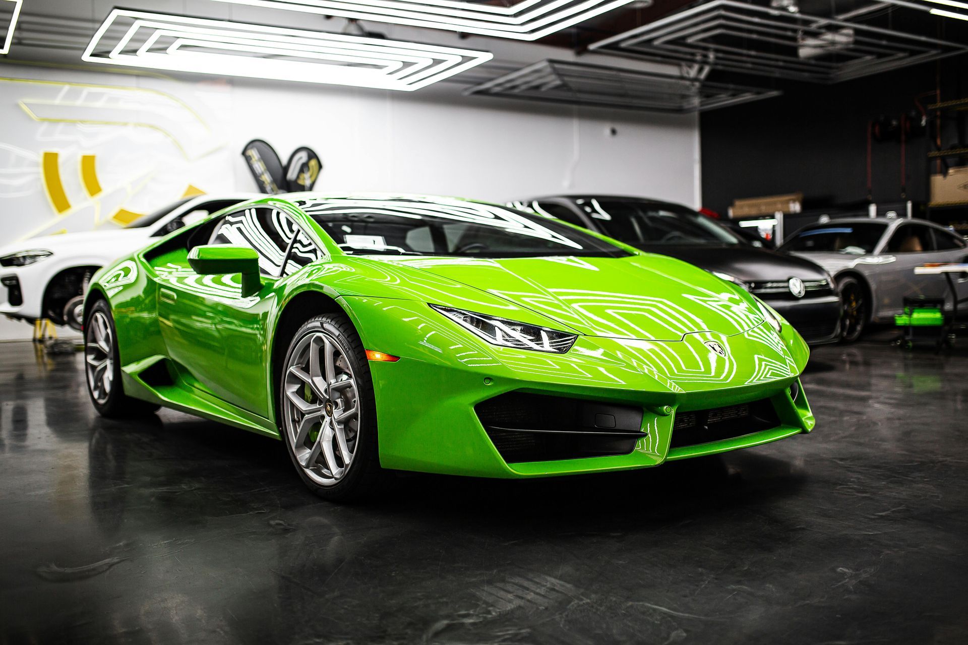 A green lamborghini huracan is parked in a garage.