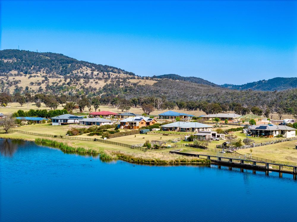 An Aerial View of A Residential Area Next to A Lake with Mountains in The Background — Solar Blessing in Tenterfield, NSW