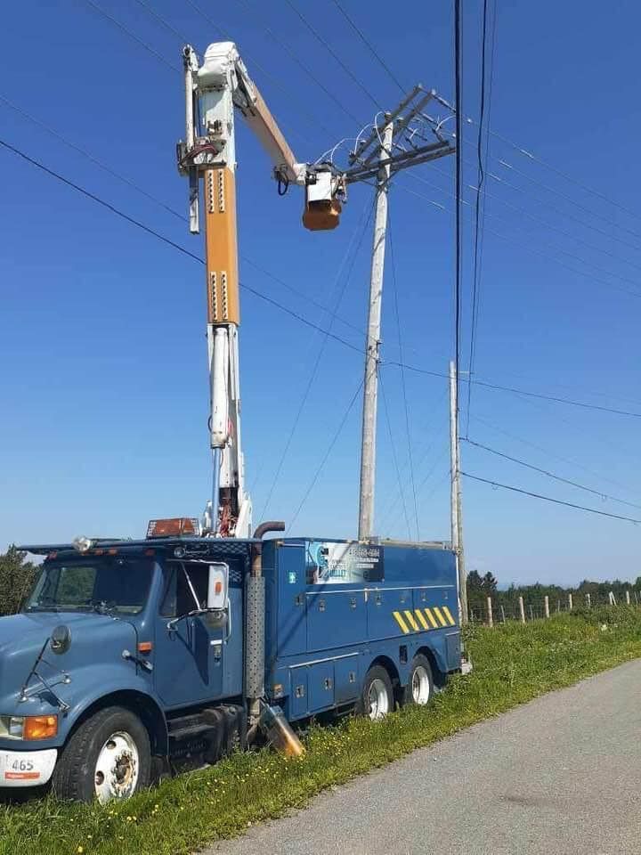 Un camion bleu est garé à côté d'une ligne électrique