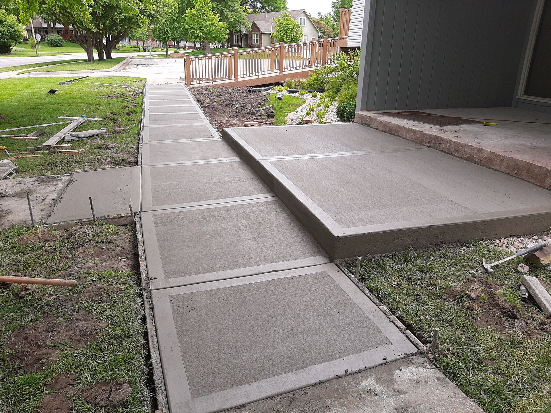 a woman is walking down a sidewalk next to a concrete barrier .