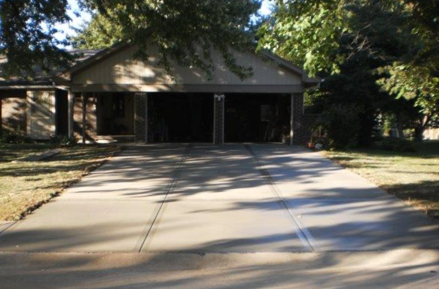 a driveway leading to a house with two garages