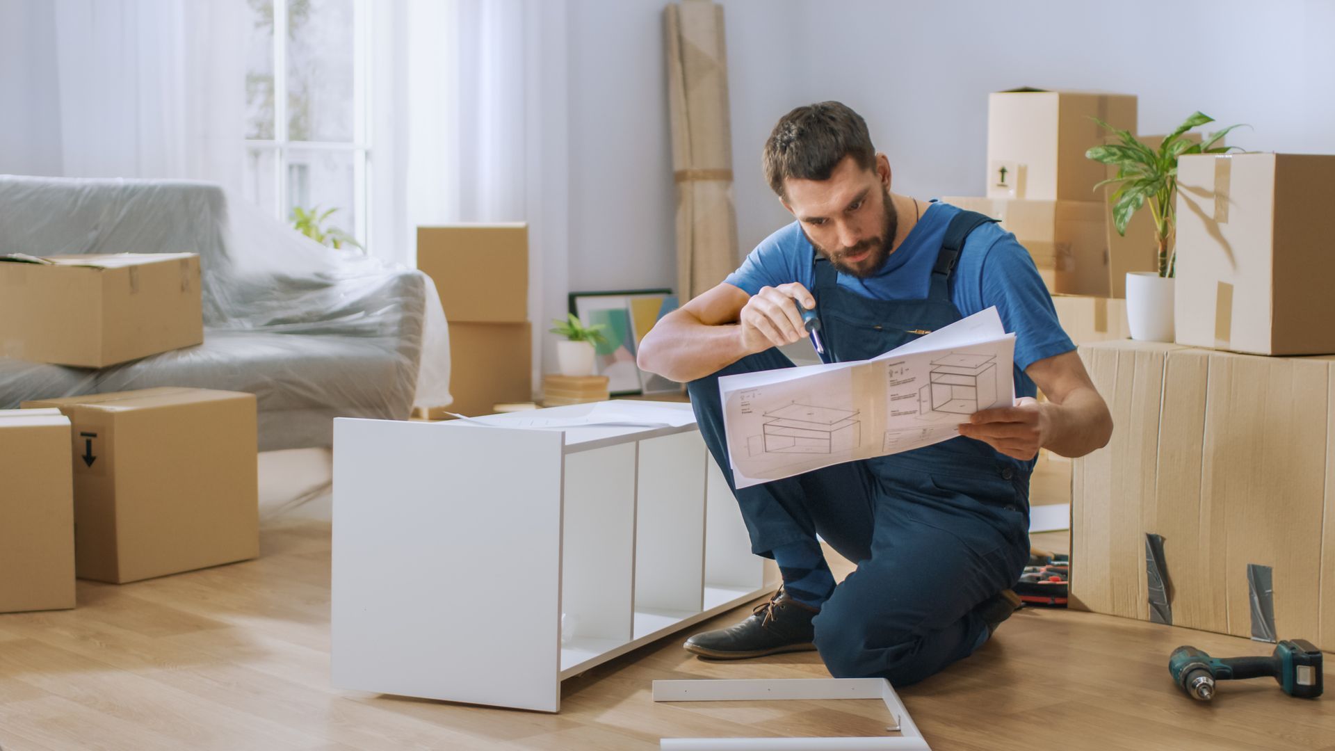 A living room filled with cardboard boxes and a guitar.
