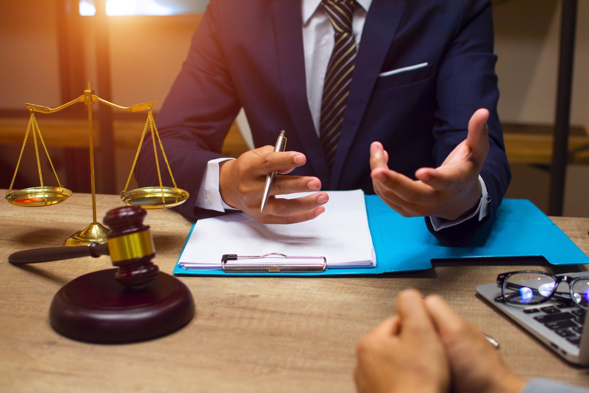 a lawyer is sitting at a desk talking to a client