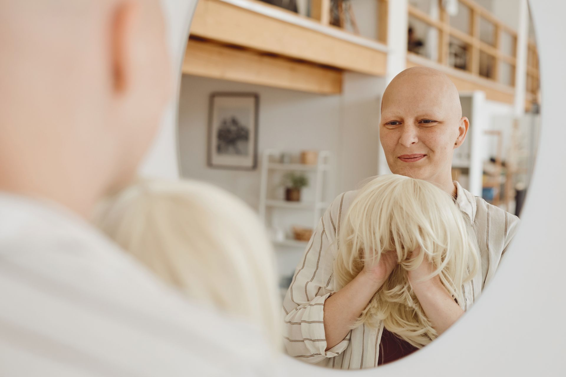 a woman with a wig on looks at herself in a mirror