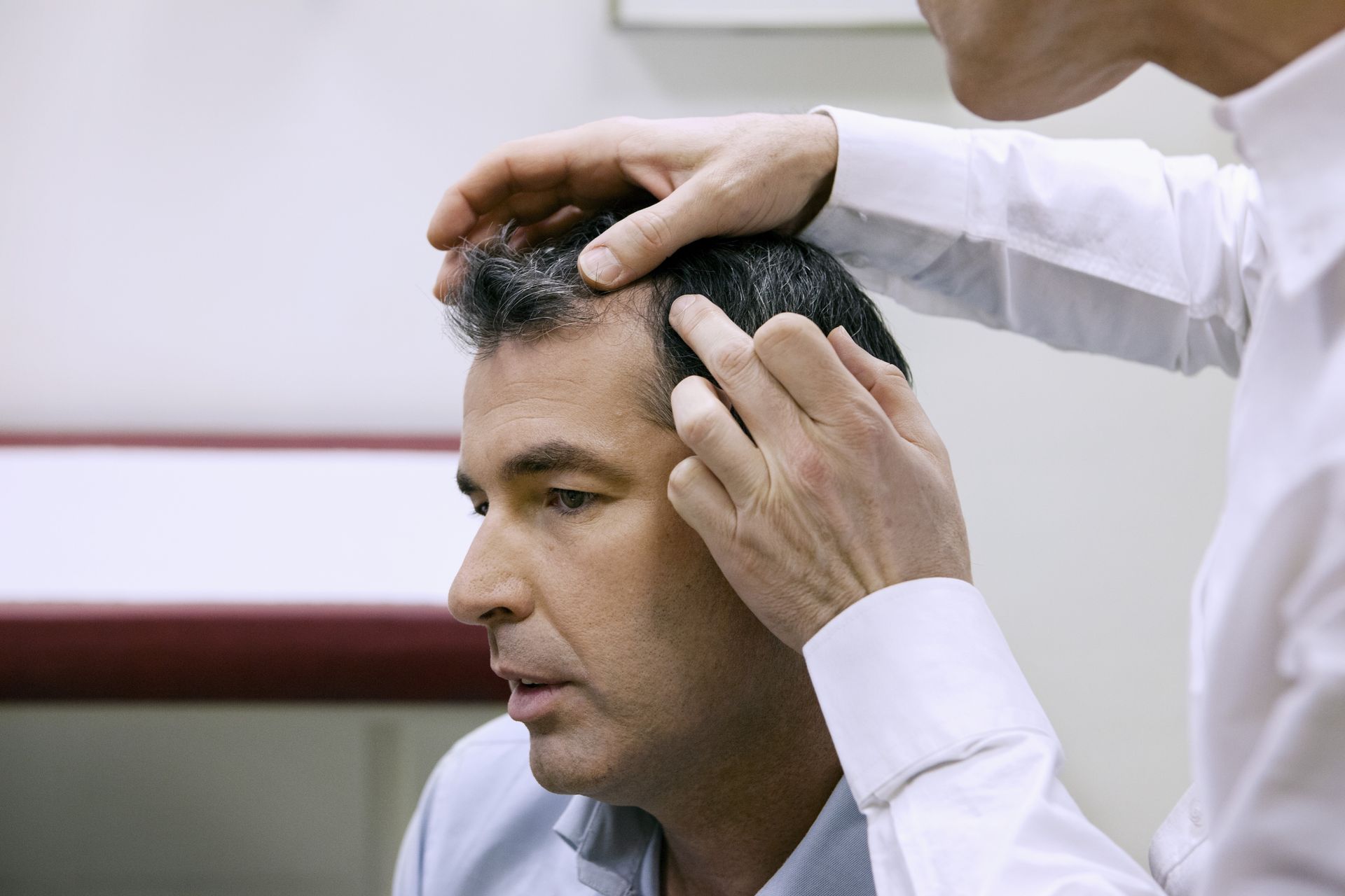 a man is getting his hair examined by a doctor
