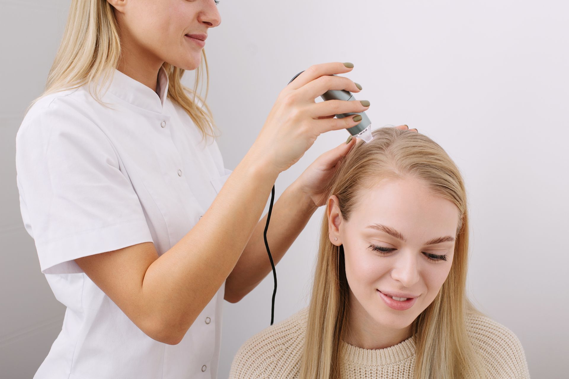 a woman is getting her hair examined by a doctor