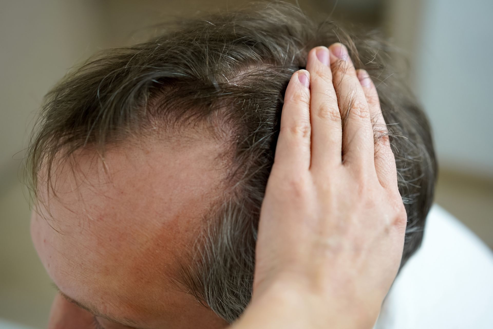 a man 's hair is being touched by a woman 's hand