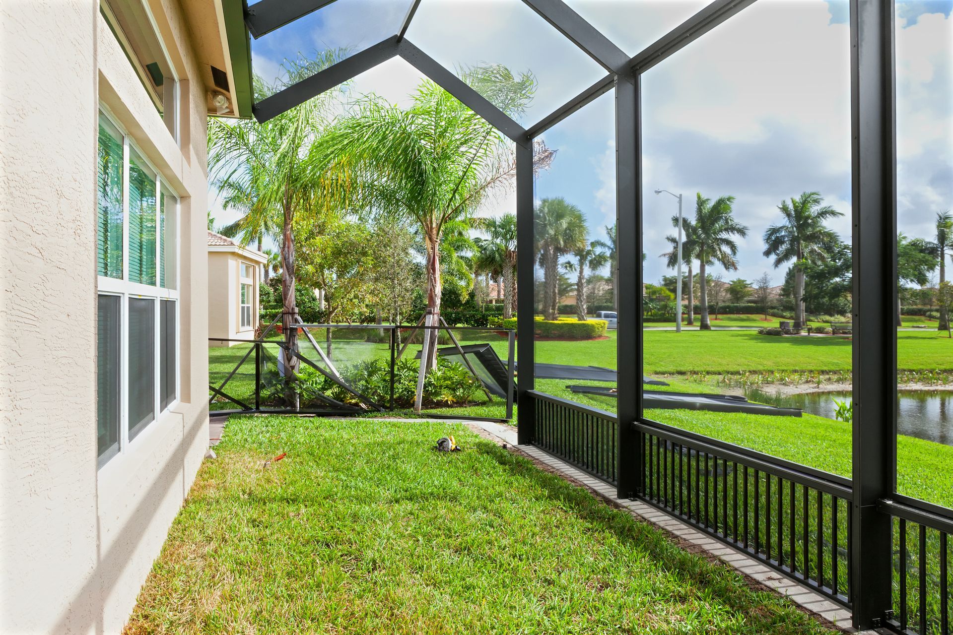 View from a screened-in porch at David Wesley's Patio Rooms, featuring lush grass and trees. 