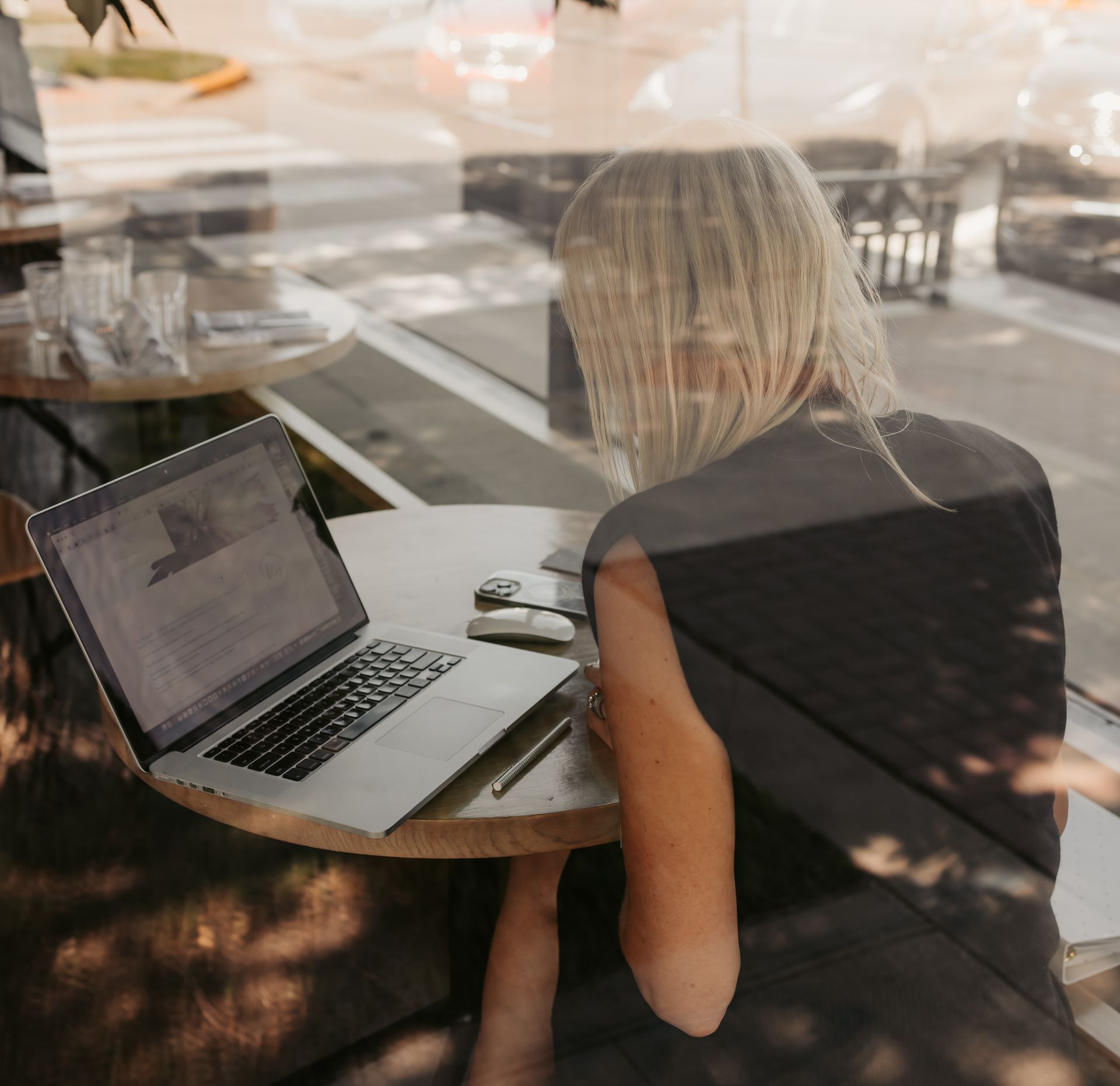 A woman is sitting at a table with a laptop on it