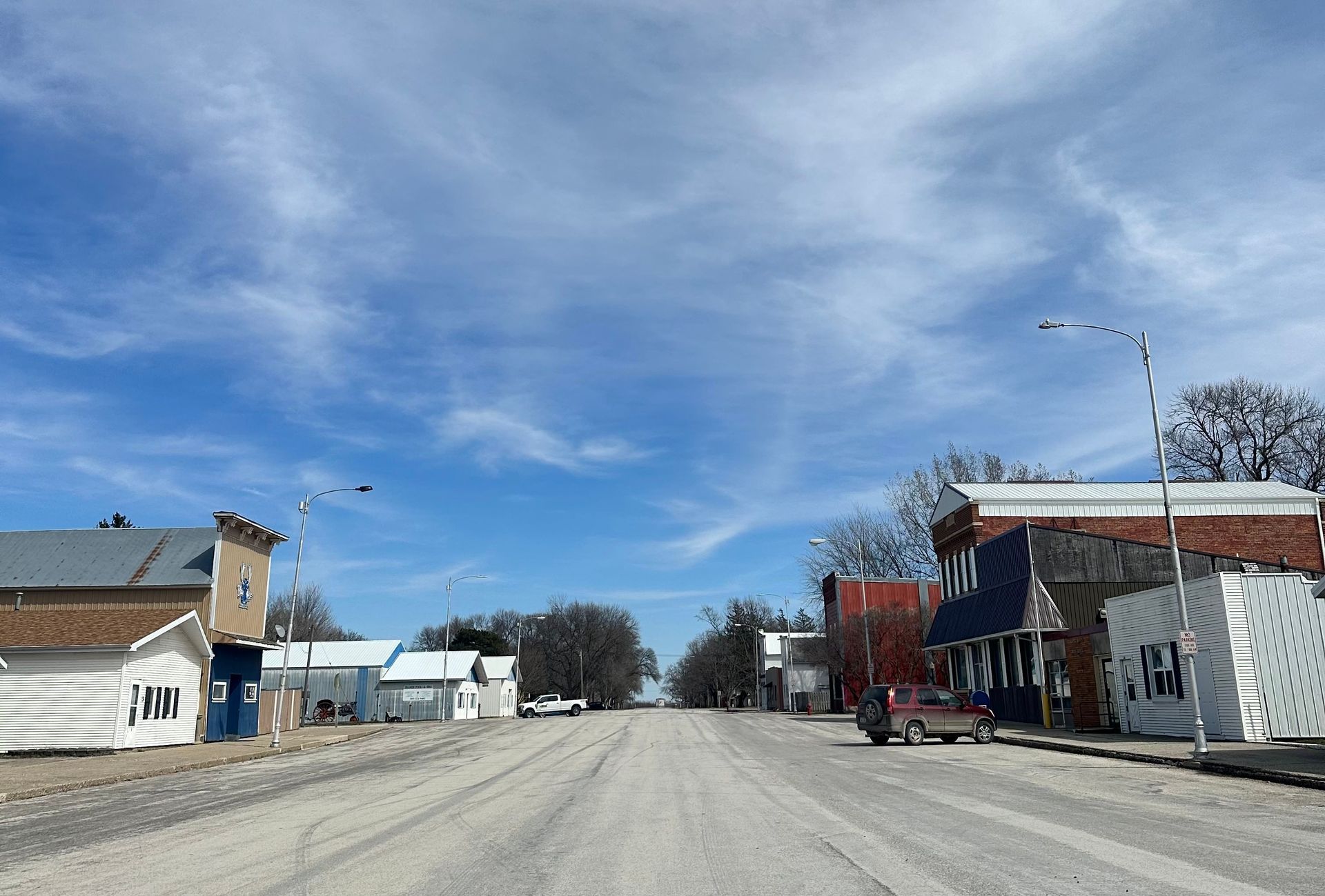 A street in Renwick, Iowa, with a lot of buildings on it and a blue sky with clouds.