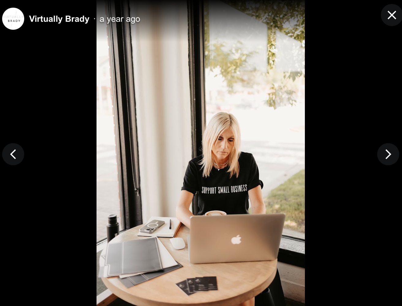 A woman is sitting at a table using a laptop computer.