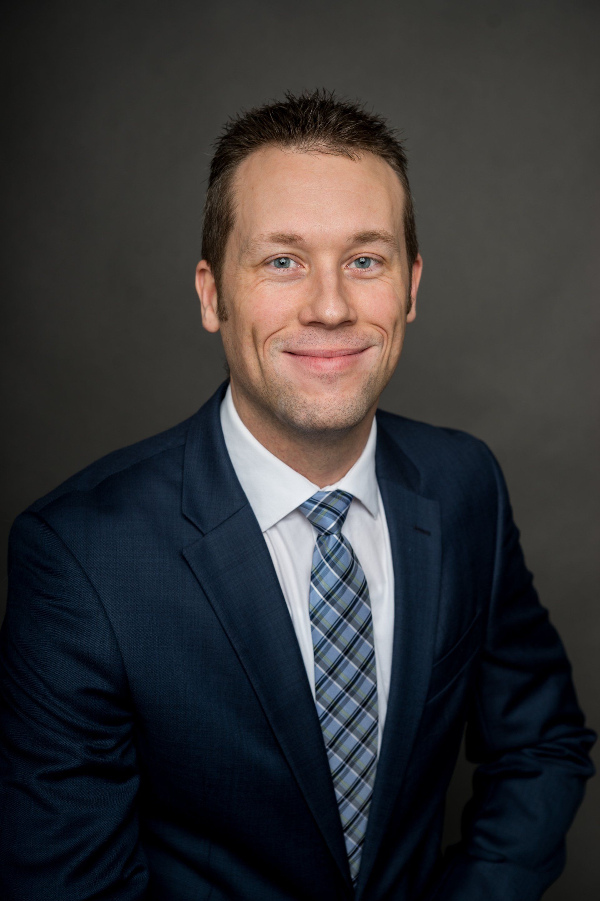 A man in a suit and tie is smiling for the camera.