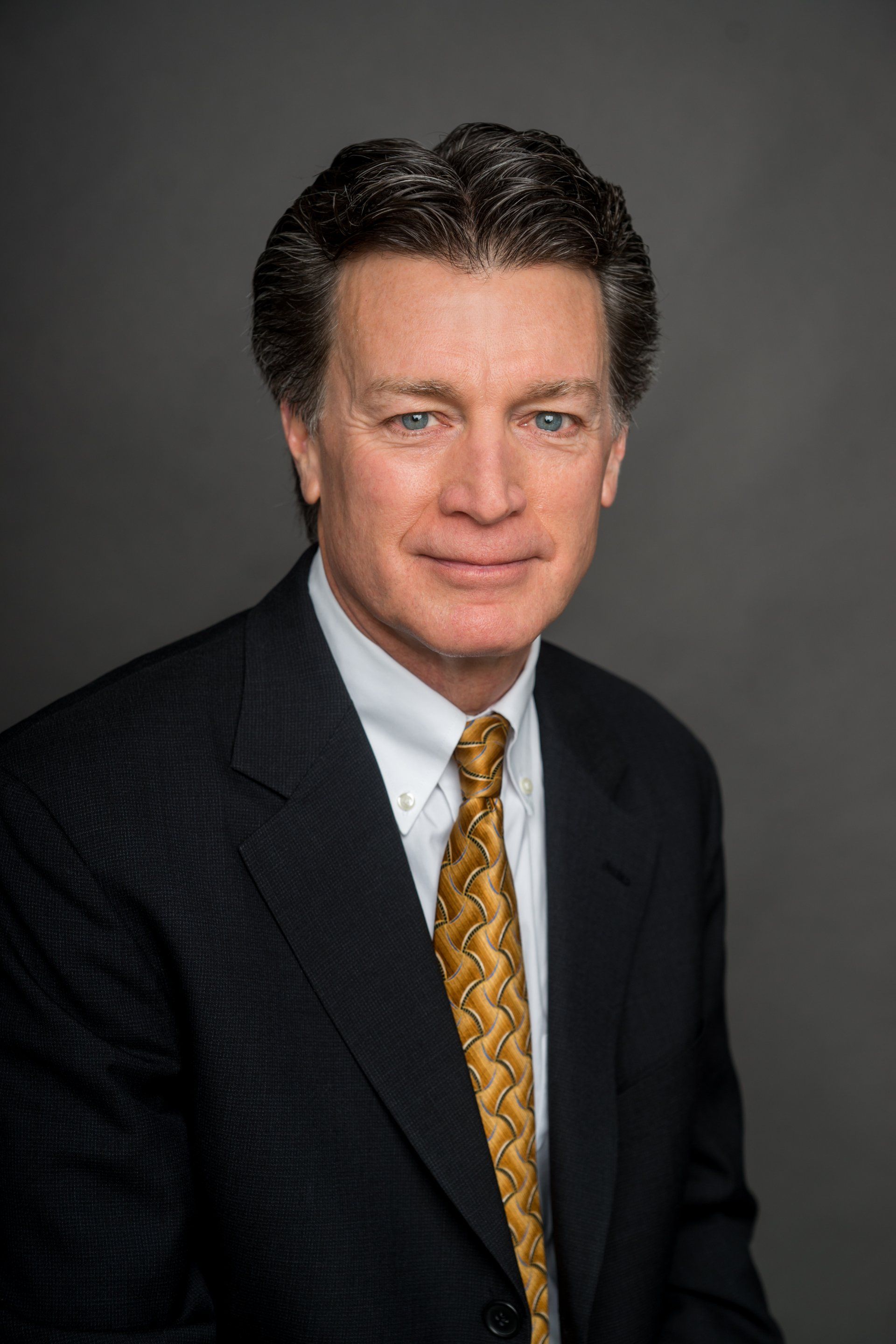A man in a suit and tie is smiling for the camera.