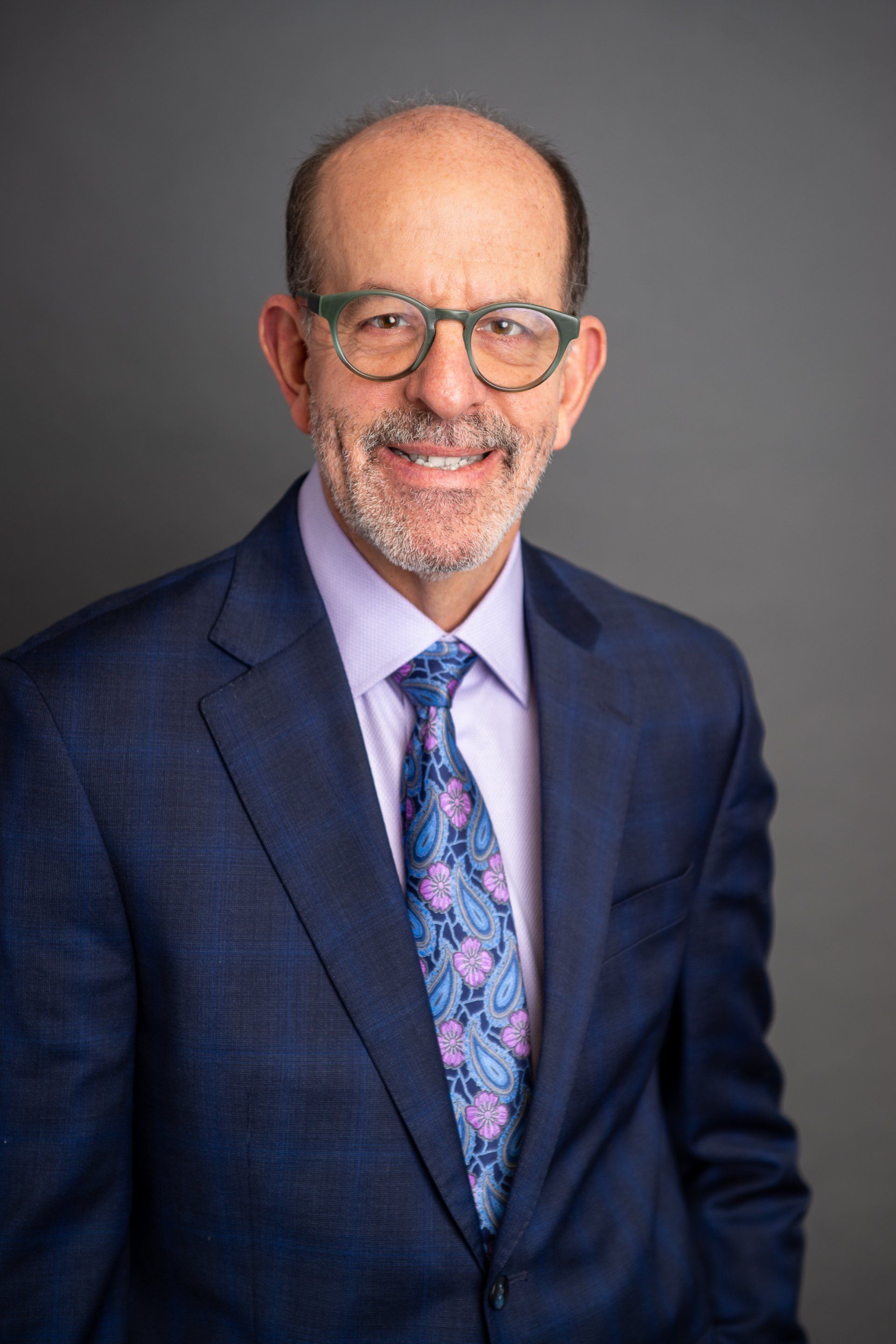 A man in a suit and tie is smiling for the camera.
