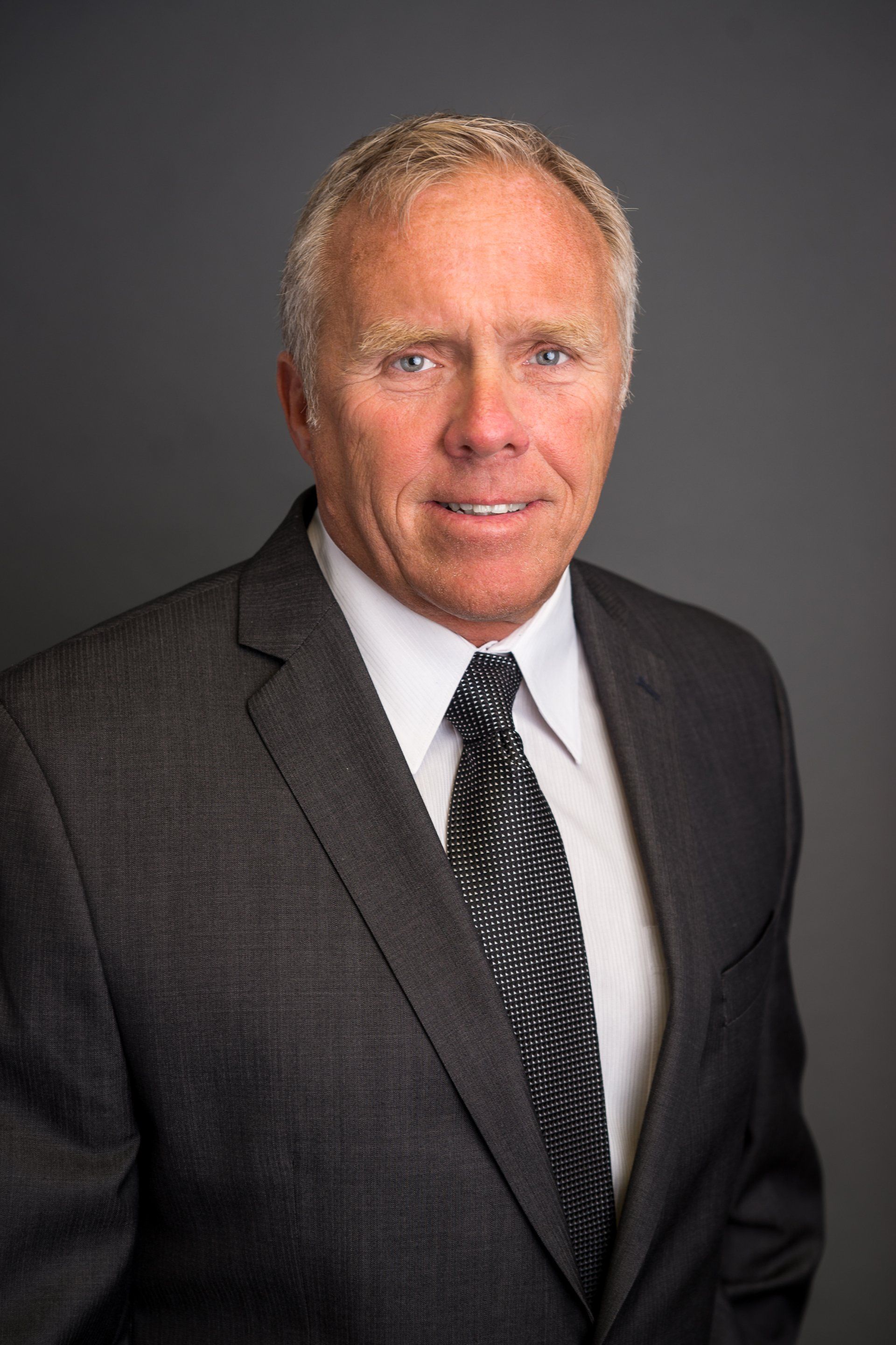 A man in a suit and tie is smiling for the camera.