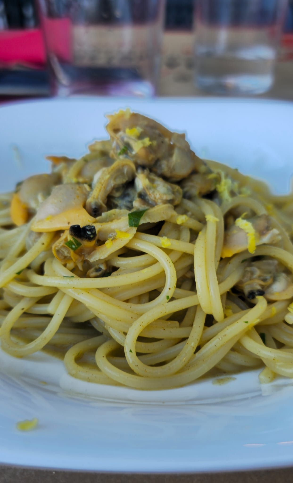 Un tavolo e delle sedie in un ristorante con un vaso di fiori sopra.