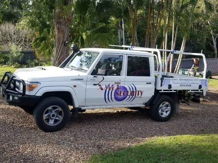 White Security Truck Parked on Gravel With Security Logo — X-Mod Security In Landsborough, QLD