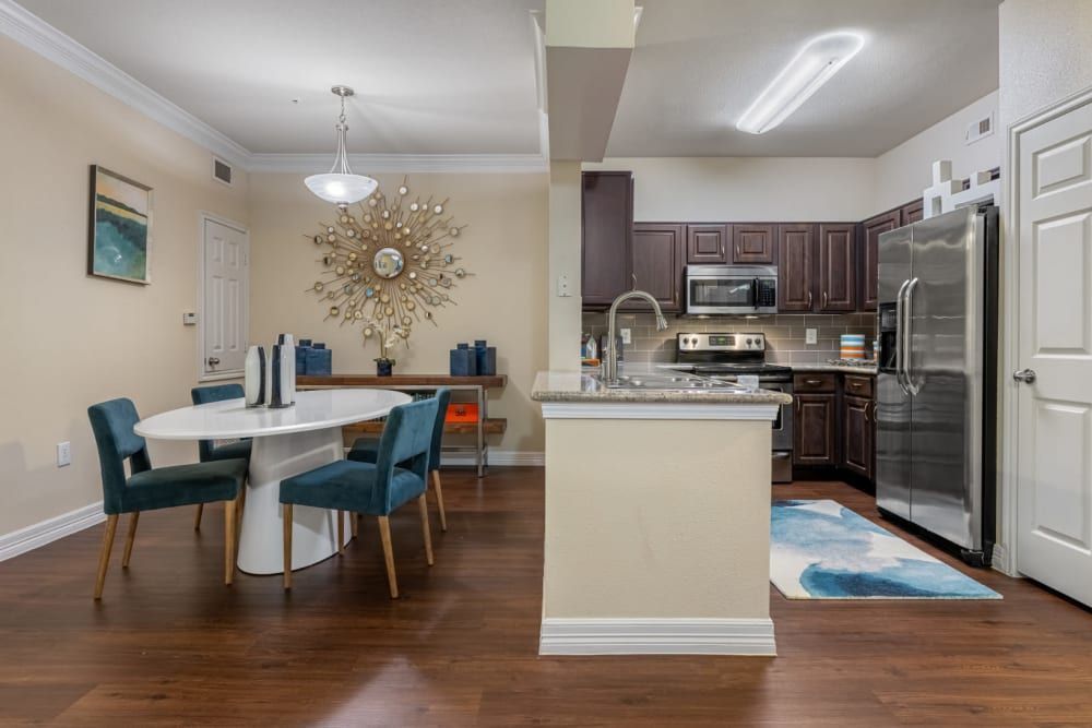 a kitchen and dining room in a house with a table and chairs at Marquis at Kingwood in Kingwood, TX.
