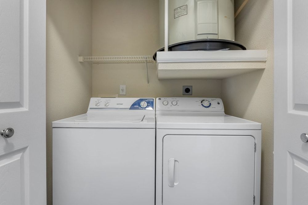 a washer and dryer are stacked on top of each other in a laundry room at Marquis at Kingwood in Kingwood, TX.