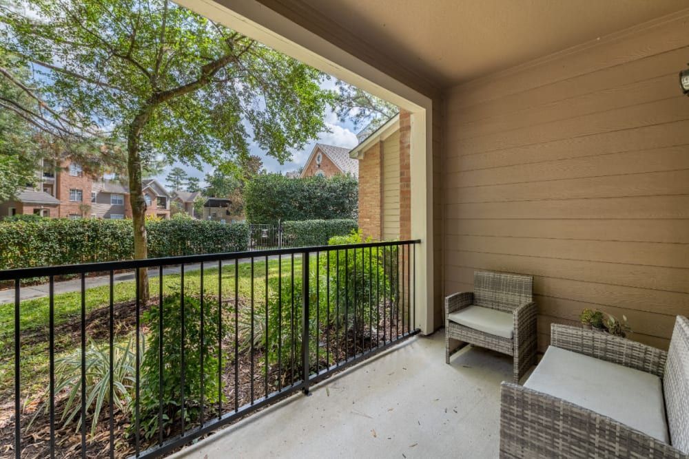 a balcony with a couch and chair on it at Marquis at Kingwood in Kingwood, TX.