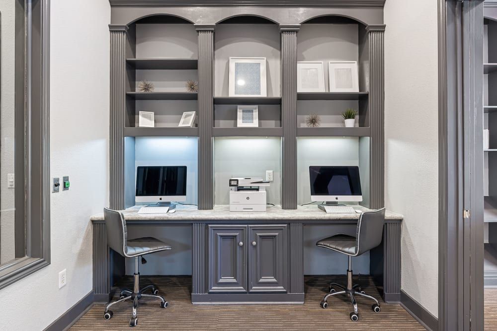 two desks with computers and a printer in the room at Marquis at Kingwood in Kingwood, TX.