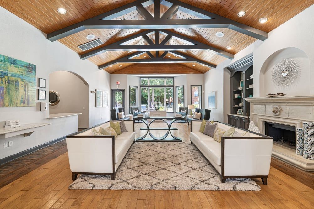 a living room with two couches, a fireplace, and a rug at Marquis at Kingwood in Kingwood, TX.
