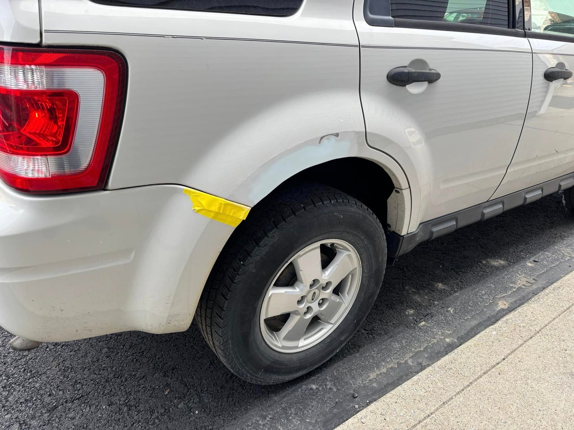 A silver suv with a yellow sticker on the side of it