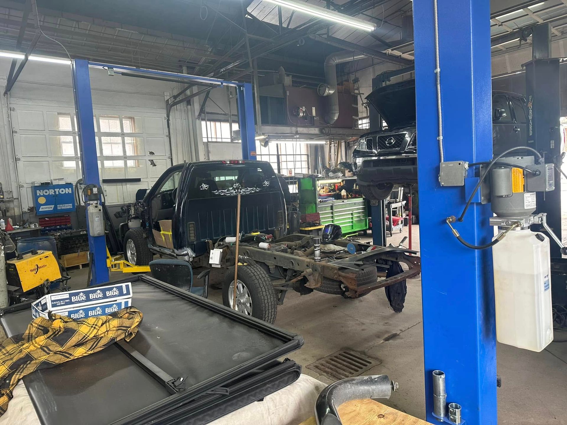 A truck is sitting on a lift in a garage.