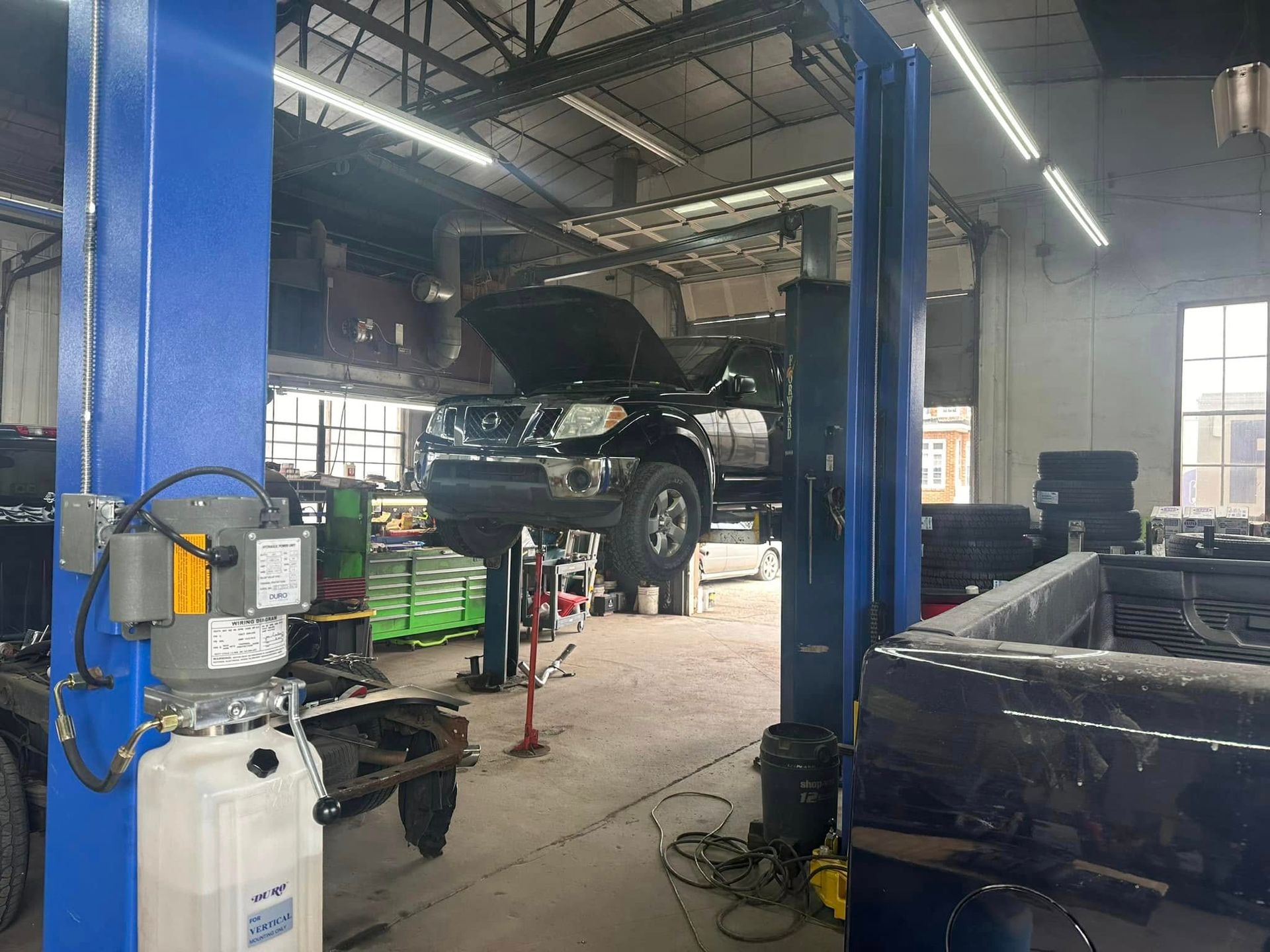 A car is sitting on a lift in a garage.