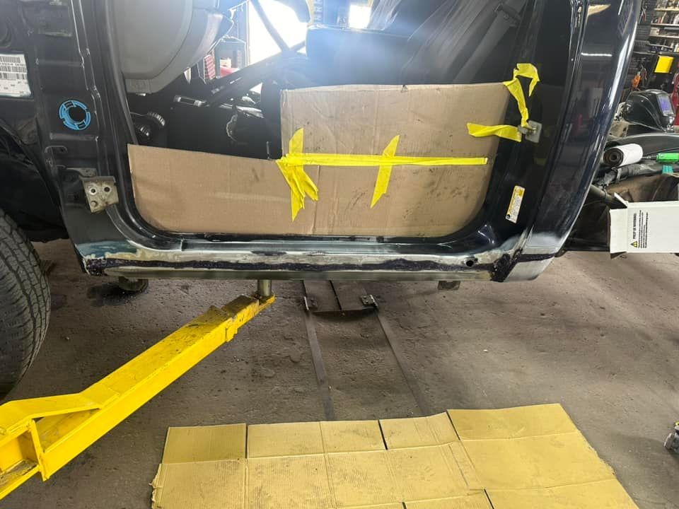 A car is sitting on a yellow lift in a garage.
