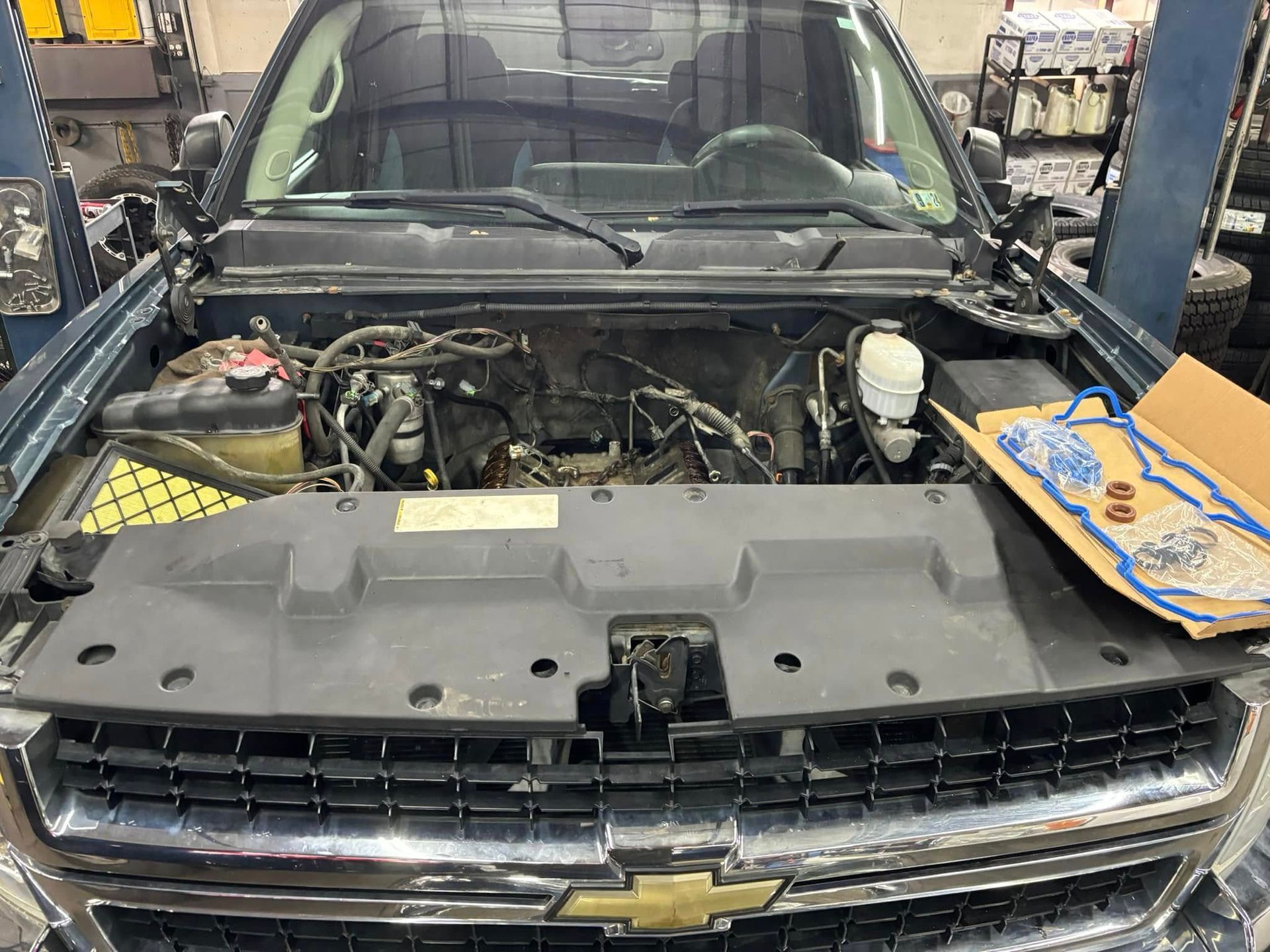 The hood of a chevrolet truck is open in a garage.