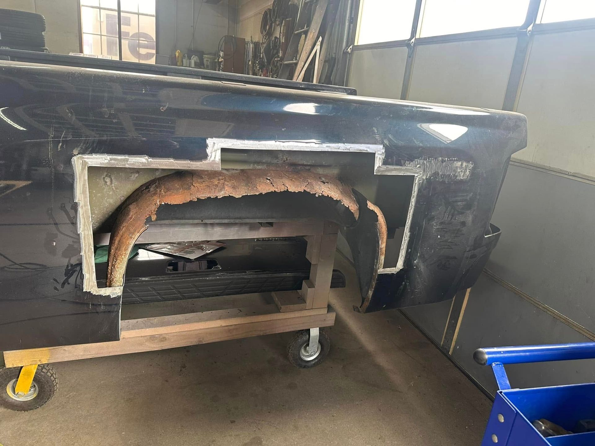 A truck is sitting on a cart in a garage.